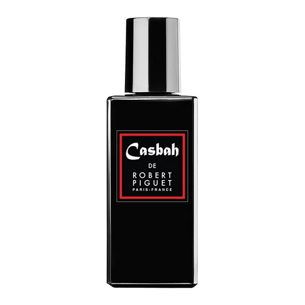 Piguet - Casbah zeigt schwarzen rechteckigen Parfumflakon mit rotem Etikett und glänzendem silbernen Verschluss