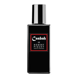 Piguet - Casbah zeigt schwarzen rechteckigen Parfumflakon mit rotem Etikett und glänzendem silbernen Verschluss