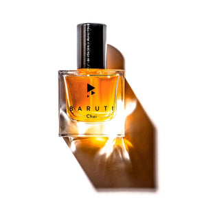 Baruti - Chai Parfumflakon mit quadratischem Glas und bernsteinfarbenem Duftöl vor weißem Hintergrund mit Schattenwurf