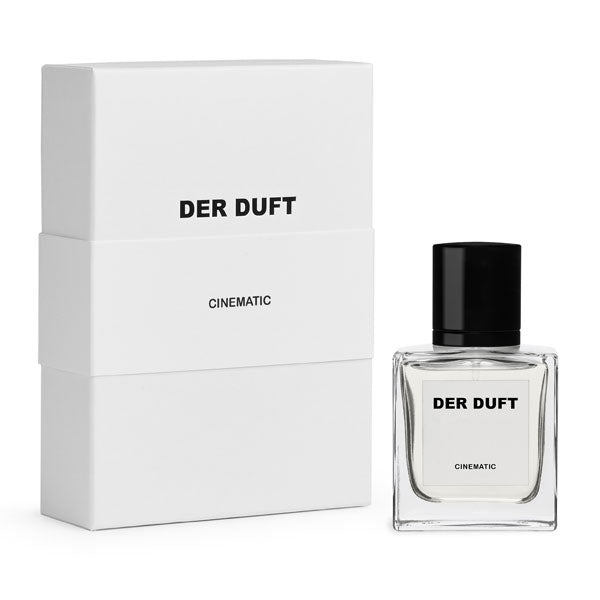 DER DUFT - Cinematic Parfumflakon mit klarem Glas und schwarzem Verschluss neben minimalistischer weißer Verpackung