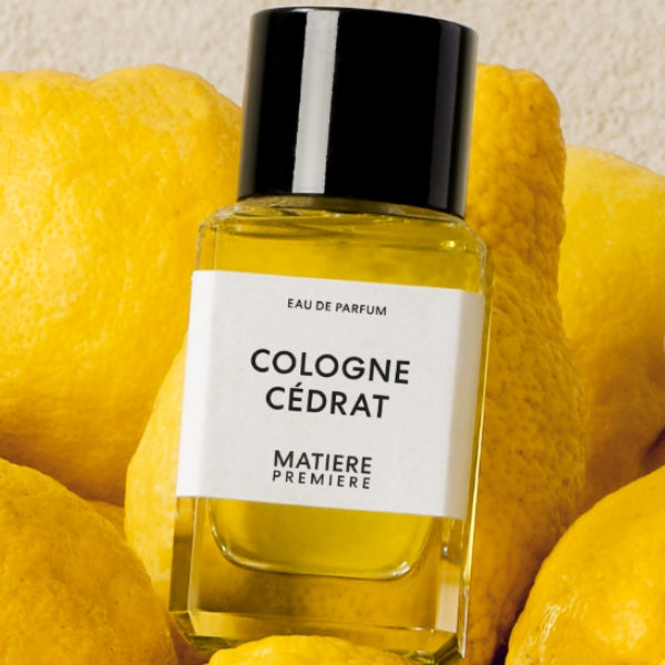 Matière Première - Cologne Cédrat zeigt klaren Flakon mit gelbem Parfum vor leuchtend frischen Zitronen im Hintergrund