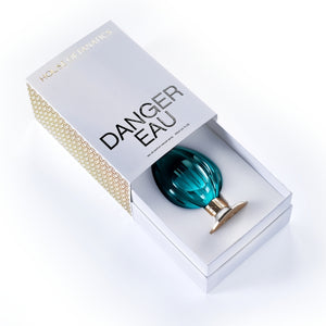 House of Fanatics - Danger Eau präsentiert exklusiven Flakon in tiefblauem, facettiertem Glas mit goldfarbenem Sockel in edler Schachtel