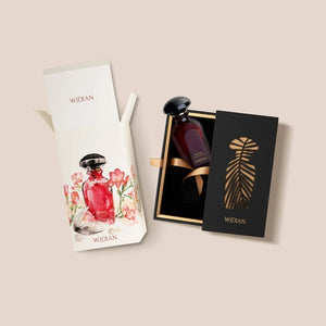 Widian - Velvet Collection - Delma Parfumflakon in dunkelrotem Glas mit schwarzem Deckel in schwarzer Geschenkbox neben floral gestaltetem Karton