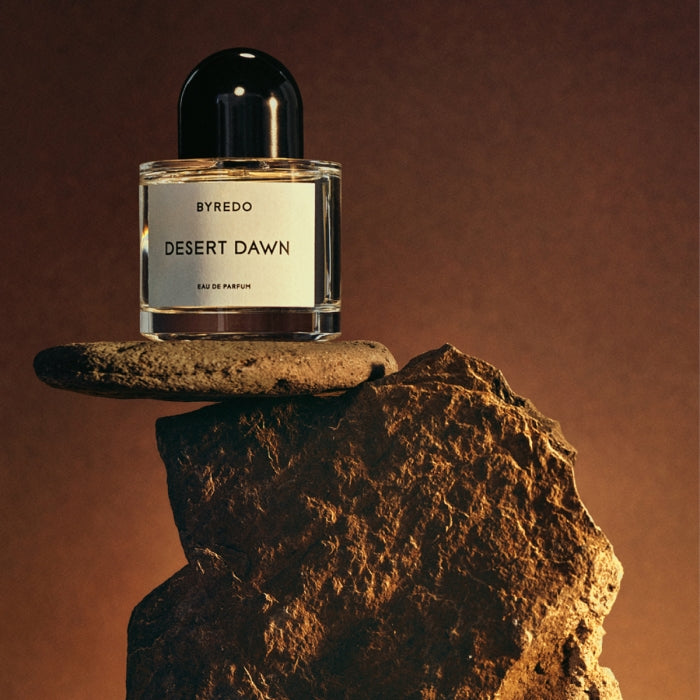 Byredo - Desert Dawn Parfumflakon auf natürlichem Stein, warmes Licht hebt die schlichte Eleganz hervor