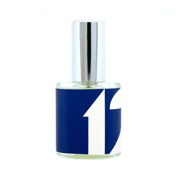 Erik Kormann - Dezember Parfumflakon mit klarem Glas und blau-weißem Etikett in modernem, schlichtem Design