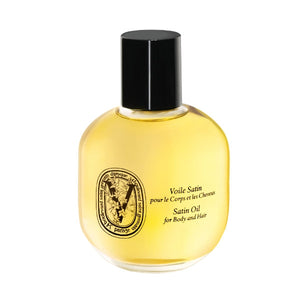 Diptyque - Satin Oil for Body and Hair in transparentem Flakon mit schwarzem Verschluss vor weißem Hintergrund