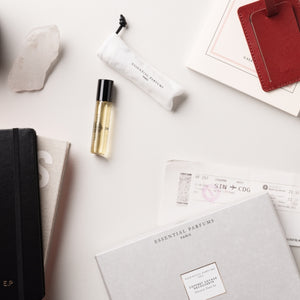 Essential Parfums - Travel Set - Voyage in a Bottle mit elegantem Reisespray und stilvollem Beutel auf hellem Hintergrund