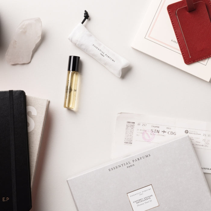 Essential Parfums - Travel Set - Voyage in a Bottle mit elegantem Reisespray und stilvollem Beutel auf hellem Hintergrund