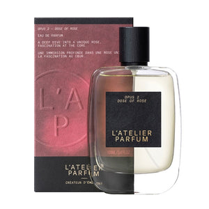 L'Atelier Parfum - Opus 2 - Dose of Rose Flakon mit schwarzem Etikett vor zweifarbigem rosafarbenem und schwarzem Hintergrund