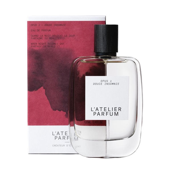 L'Atelier Parfum - Opus 1 - Douce Insomnie klarer Flakon mit schwarzem Holzverschluss vor dunkelrotem Karton