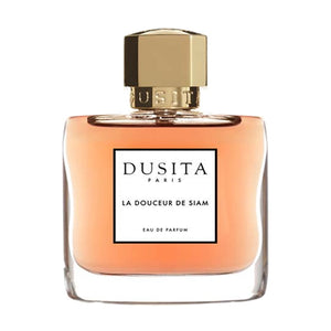Dusita - La Douceur de Siam Parfumflakon mit warmem Bernsteinfarbton und goldenem Verschluss vor weißem Hintergrund