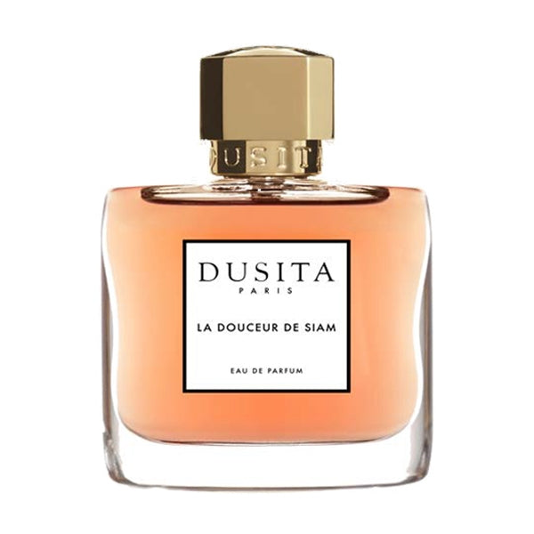 Dusita - La Douceur de Siam Parfumflakon mit warmem Bernsteinfarbton und goldenem Verschluss vor weißem Hintergrund