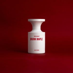 BORNTOSTANDOUT - Drunk Maple Parfumflakon in minimalistischem Weiß mit rotem Schriftzug auf tiefrotem Hintergrund