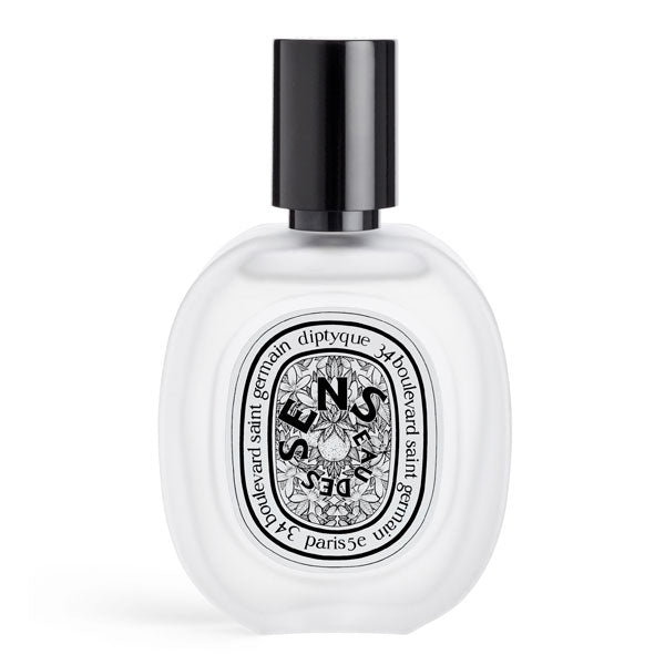 Diptyque - Eau des Sens - Hair Mist in transparentem Flakon mit schwarzem Verschluss und floralem Etikett