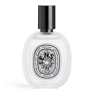 Diptyque - Eau des Sens - Hair Mist in transparentem Flakon mit schwarzem Verschluss und floralem Etikett