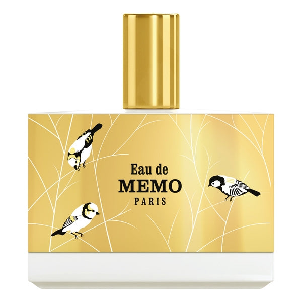 Memo Paris - Eau de Memo Parfumflakon mit goldfarbenem Oberteil und zartem Vogeldesign auf hellem Hintergrund