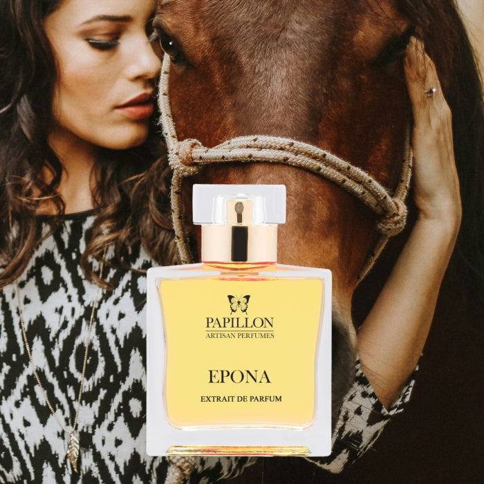 Papillon Perfumery - Epona Parfumflakon mit bernsteinfarbener Flüssigkeit vor Frau und Pferd in natürlicher Umgebung