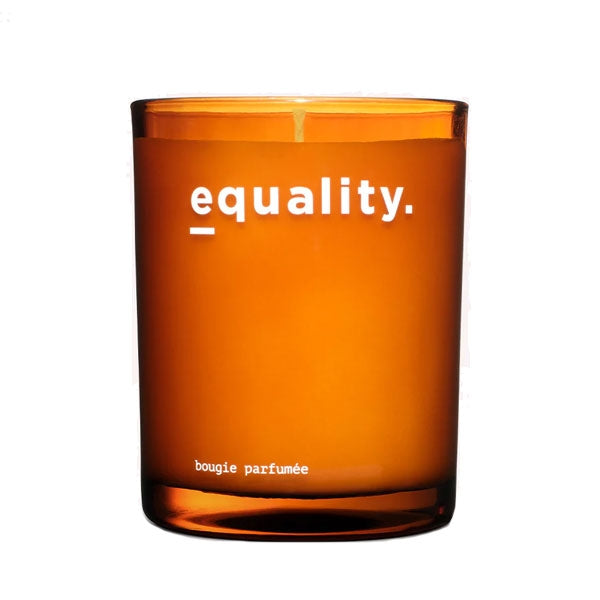 equality. fragrances - equality. candle in orangefarbenem Glas mit schlichter weißer Schrift minimalistisch fotografiert