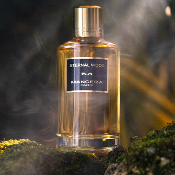 Mancera - Eternal Wood Parfumflakon in warmem Bernstein mit schwarzem Etikett umgeben von mystischem Nebel im Naturambiente