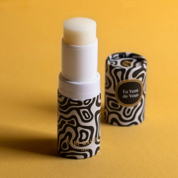 Sabé Masson - Eu Vent de Vous - Solid Soft Perfume mit schwarz-weiß gemusterter Verpackung vor gelbem Hintergrund