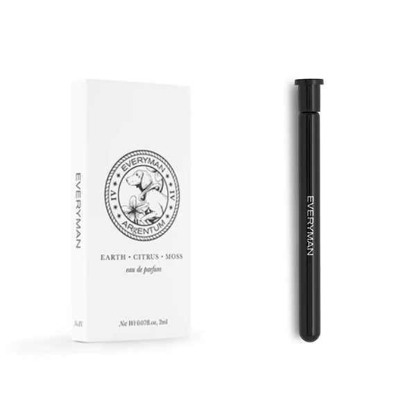 Argentum - Everyman - Earth schlanker schwarzer Duftroller neben minimalistischer weißer Verpackung mit Erde- und Zitrusmotiv