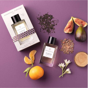 Essential Parfums - Fig Infusion Parfumflakon mit schwarzem Verschluss, frischen Feigen und Zitrusfrüchten auf violettem Hintergrund