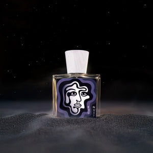 Carl Kling Parfums - Fig Nuit zeigt rechteckigen Flakon mit abstraktem Gesichtsmotiv und hellem Holzverschluss vor dunklem Hintergrund