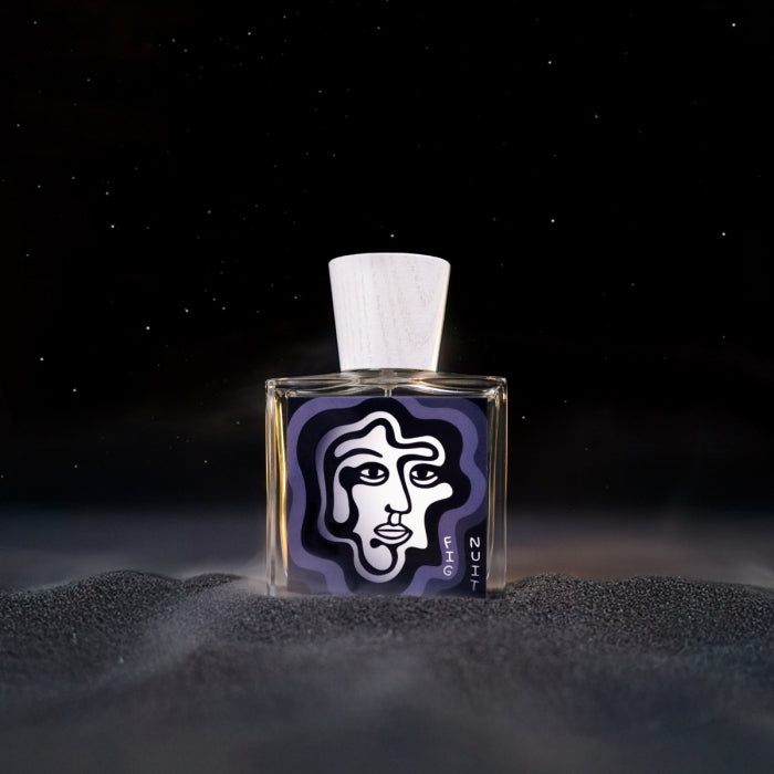 Carl Kling Parfums - Fig Nuit zeigt rechteckigen Flakon mit abstraktem Gesichtsmotiv und hellem Holzverschluss vor dunklem Hintergrund