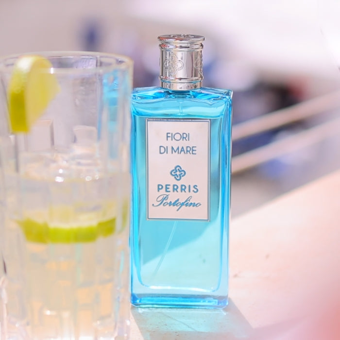 Perris Monte Carlo - Portofino - Fiori di Mare blauer Flakon mit silbernem Verschluss neben Glas mit Limettenscheiben