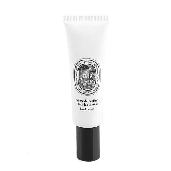 Diptyque - Fleur de Peau - Hand Cream in schlanker weißer Tube mit schwarzem Drehverschluss vor hellem Hintergrund