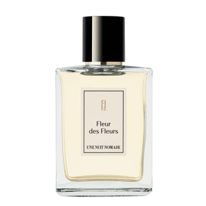 Une Nuit Nomade - Une Nuit a Bali - Fleur des Fleurs Flakon mit schlichter Eleganz und zart gelber Flüssigkeit vor weißem Hintergrund