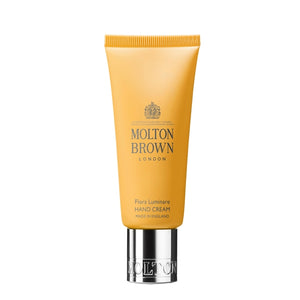Molton Brown - Flora Luminare Hand Cream in gelber Tube mit silbernem Verschluss vor weißem Hintergrund