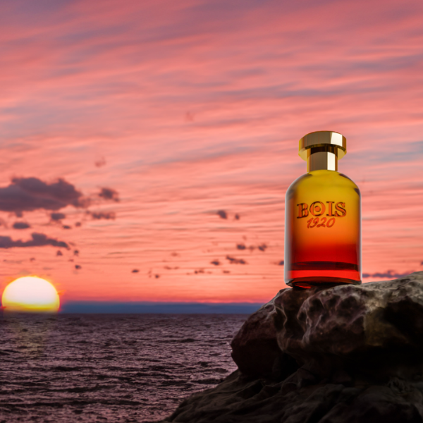 Bois 1920 - Trasparenti - Gioco all’Alba Flakon mit goldfarbenem Verschluss vor malerischem Sonnenaufgang am Meer