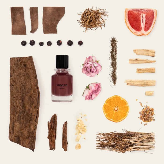 Fugazzi - Goudh Parfumflakon mit warmen, holzigen und zitrusfrischen Ingredienzien kunstvoll arrangiert auf hellem Hintergrund