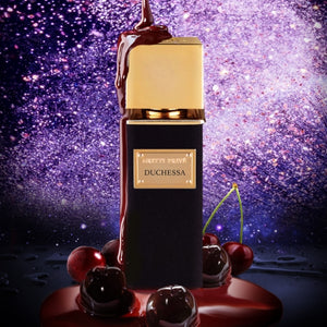 Gritti - Parfum Privée - Duchessa schwarzer Flakon mit goldfarbenem Deckel umgeben von Kirschen und dunkler Flüssigkeit vor glitzerndem Hintergrund