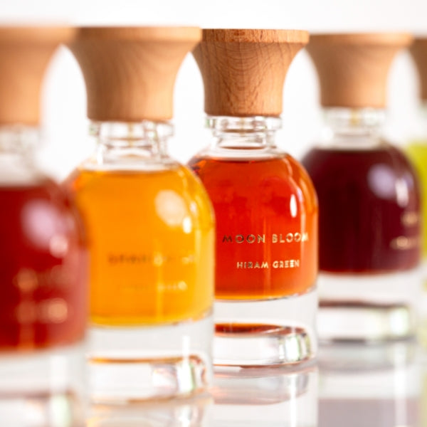Hiram Green - Moon Bloom Parfumflakon mit klarem Glas, bernsteinfarbenem Duft und naturfarbenem Holzverschluss elegant präsentiert