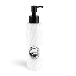 Diptyque - Philosykos - Hand & Body Lotion in eleganter weißer Flasche mit Schwarzem Pumpspender auf hellem Hintergrund