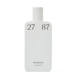 27 87 - #hashtag Parfumflakon in schlichtem, mattem Weiß mit minimalistischer schwarzer Beschriftung vor weißem Hintergrund