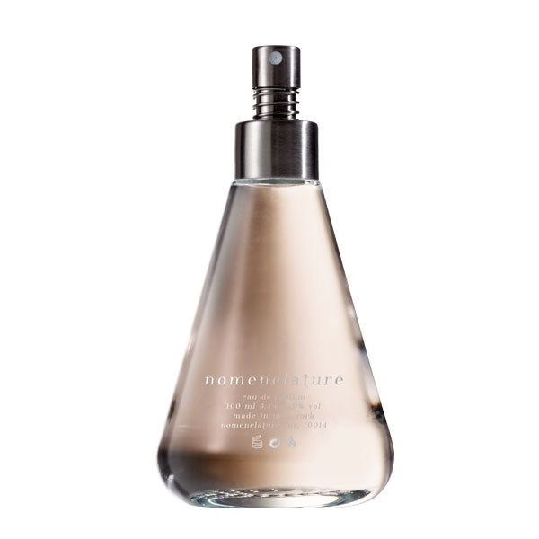 Nomenclature - holy_wood Parfumflakon mit trapezförmigem Glas und metallischem Zerstäuber vor weißem Hintergrund