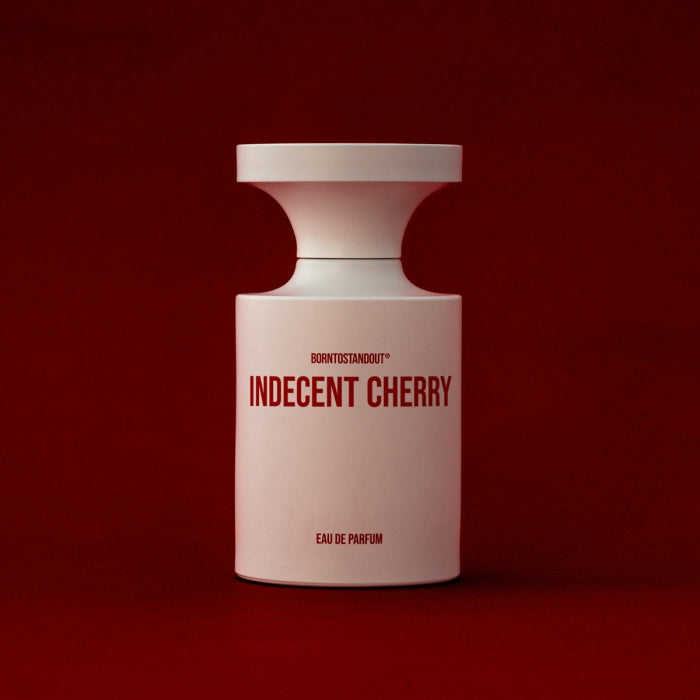 BORNTOSTANDOUT - Indecent Cherry Parfumflakon in elegantem Weiß mit roter Schrift vor tiefrotem Hintergrund