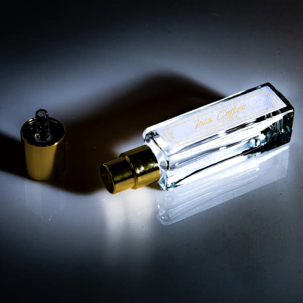 Cherigan - Iris Coffee Parfumflakon mit rechteckiger Glasform und goldenem Zerstäuber auf dunklem Untergrund