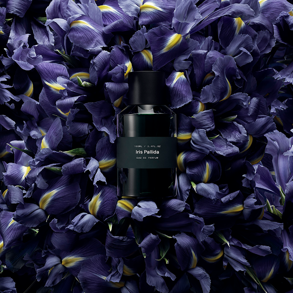 Marie Jeanne - Iris Pallida Parfumflakon umgeben von Irisblüten in tiefem Violett mit gelben Akzenten
