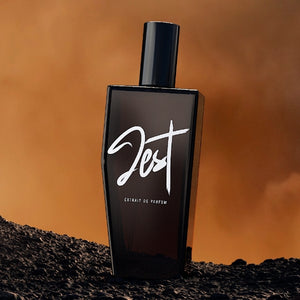 Andrea Maack Parfums - Jest dunkler Parfümflakon mit markantem Schriftzug vor warmem braunem Hintergrund
