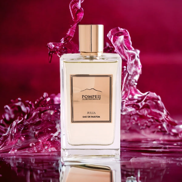 Pompeii - Julia Parfumflakon mit goldenem Verschluss vor intensivem pinkem Wasser-Splash-Hintergrund