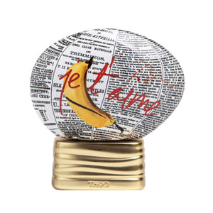 THoO - Crazy Collection - L'Explicite Flakon mit Zeitungsdruck, Banane und rotem Schriftzug auf goldenem Sockel