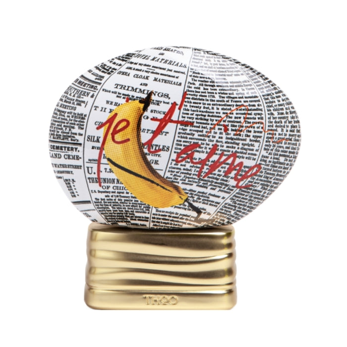THoO - Crazy Collection - L'Explicite Flakon mit Zeitungsdruck, Banane und rotem Schriftzug auf goldenem Sockel