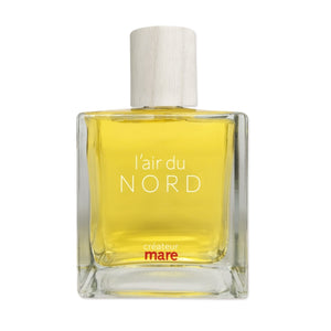 Mare - L‘Air du Nord Parfumflakon mit klarem Glas, hellem Holzverschluss und leuchtend gelbem Inhalt minimalistisch inszeniert