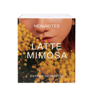 New Notes - Contemporary Blend Collection - Latte Mimosa Parfümverpackung mit Nahaufnahme von gelben Mimosen und Gesichtshälfte