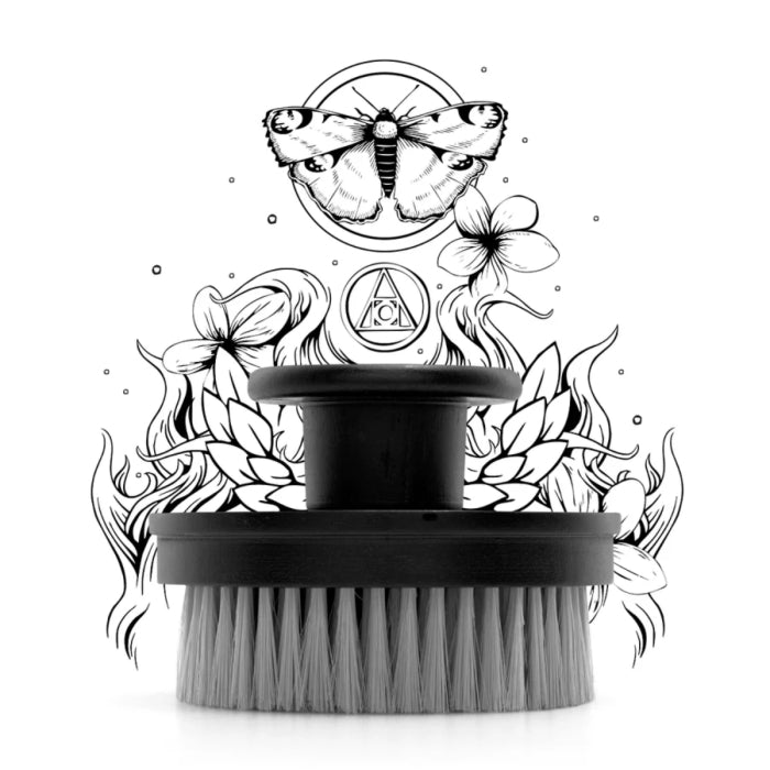 Argentum - Le Feu D’Argent Körperbürste mit rundem Griff vor abstrakter Schwarz-Weiß-Illustration