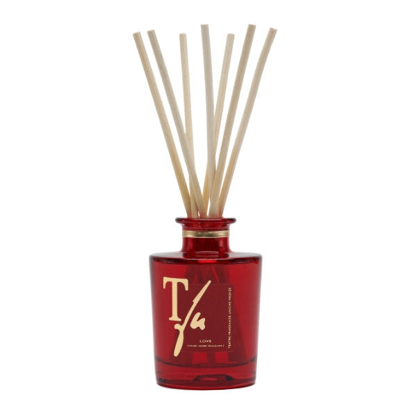 Teatro - Luxury Collection - Love - Diffusor zeigt roten Glasflakon mit goldener Schrift und naturfarbenen Diffusorstäbchen elegant arrangiert